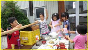 屋外で流しそうめんをする子ども達