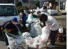 屋外で廃品回収を行う親子