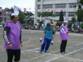 保護者が児童をおんぶして地域役員の周りを回るレース写真